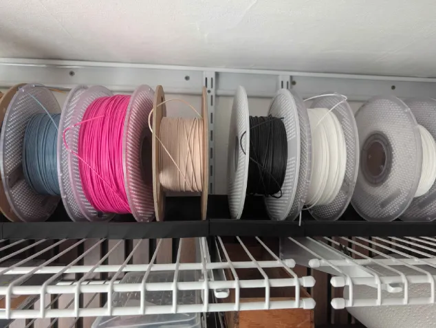 Shelf of filament spools in multiple colors for my Bambu Lab printing setup