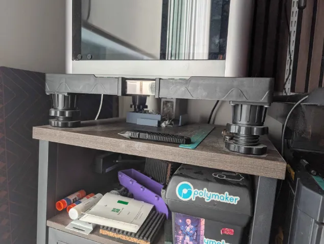 Printed riser feet supporting the X1C shelf in my printer setup
